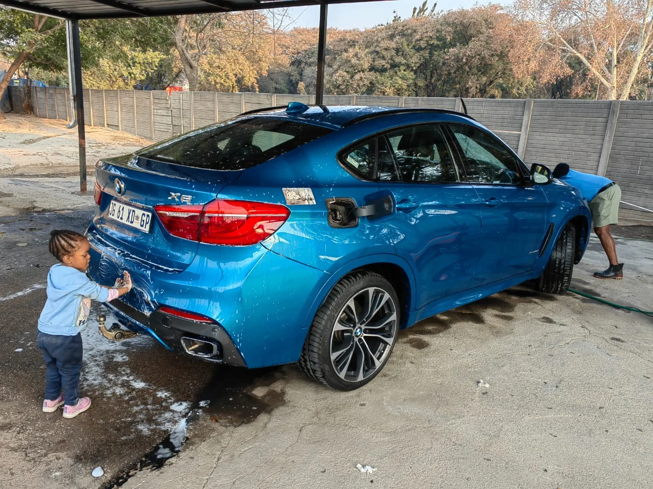 Blue BMW being washed at NTV Corner Car Wash
